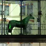 Hier sorgt das grüne Tier (wahrscheinlich ein Pferd) in luftiger Höhe für eine gewisse Spannung beim Betrachter. Ansonsten sind die gläsernen Strukturen sowie der Hintergrund klar gegliedert und unspektakulär